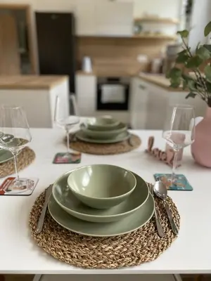 a table with two green plates and wine glasses at Sunny Oak Estate in Mengeš