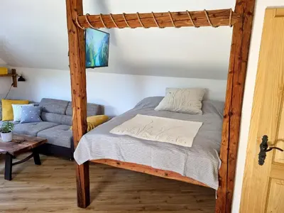 a bedroom with a bed and a couch at Apartma1 pri Adamu in Mislinja