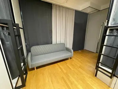 a living room with a chair and a ladder at Sleep&Go Hostel Ljubljana in Ljubljana