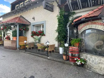 a house with a table and chairs and flowers at Rooms Balkovec in Dragatuš