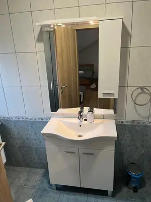 a bathroom with a white sink and a mirror at Rooms Balkovec in Dragatuš