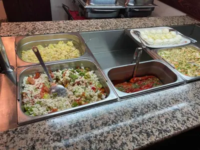 a buffet with several trays of food on a counter at Rooms Balkovec in Dragatuš