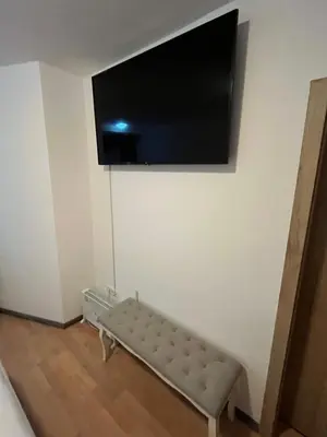 a room with a couch and a flat screen tv on a wall at Rooms Balkovec in Dragatuš