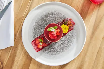 a plate of food with strawberries on a table at Thermal Resort Hotel Lendava in Lendava