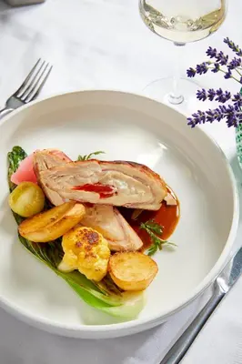 a plate of food with meat and potatoes on a table at Thermal Resort Hotel Lendava in Lendava