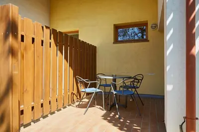 a patio with a table and chairs and a window at Thermal Apartments Lendava in Lendava