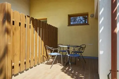 a patio with a table and chairs and a window at Thermal Apartments Lendava in Lendava