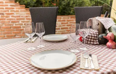 a table with plates and wine glasses on it at Apartma Rozika in Ptuj