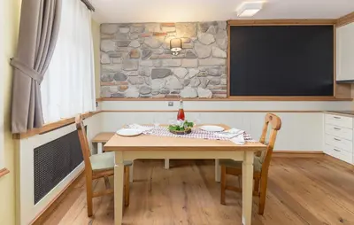 a dining room with a table with chairs and a tv at Apartma Rozika in Ptuj