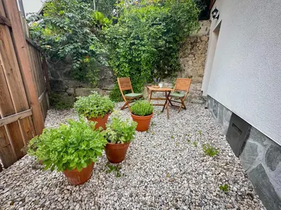 a patio with a table and chairs and potted plants at Bled House Of Green in Bled