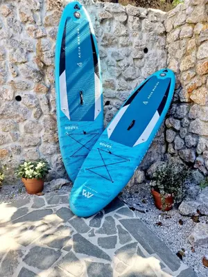 a blue surfboard leaning against a stone wall at Bled House Of Green in Bled
