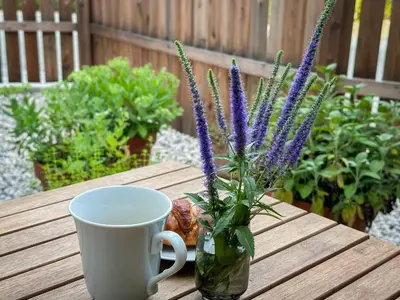 a table with a cup and a vase with purple flowers at Bled House Of Green in Bled
