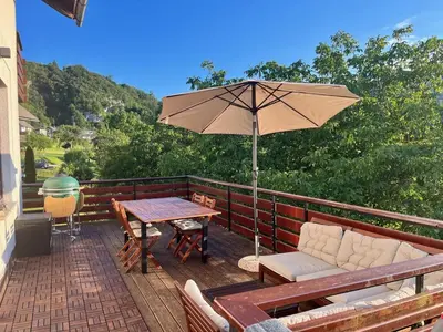 a patio with an umbrella and a table and chairs at Mountain Vista Apartment in Bled