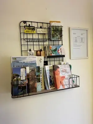 a shelf with books and magazines on a wall at Mountain Vista Apartment in Bled