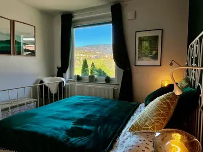 a bedroom with a bed with a large window at Mountain Vista Apartment in Bled