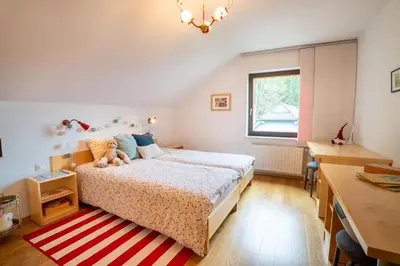 a bedroom with a bed and a desk and a window at JM Alpine Apartments in Kranjska Gora