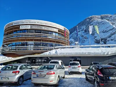 a parking lot with cars parked in front of a building at JM Alpine Apartments in Kranjska Gora
