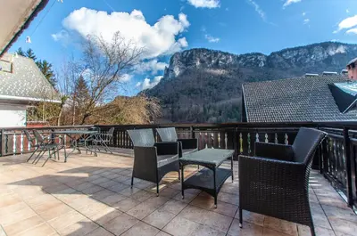 a balcony with chairs and tables and a view of mountains at Holiday Chalet near Bled in Obrne