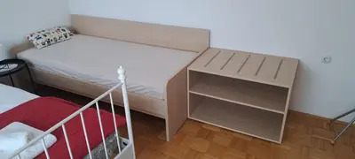 a small bedroom with a bed and a night stand at Apartma Alda in Preserje