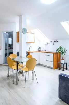 a kitchen and dining room with a table and chairs at The City Loft in Ljubljana