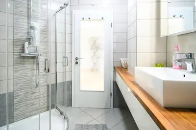 a bathroom with a sink and a shower with a glass door at The City Loft in Ljubljana