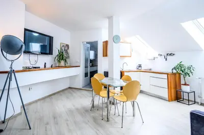 a kitchen and dining room with a table and chairs at The City Loft in Ljubljana