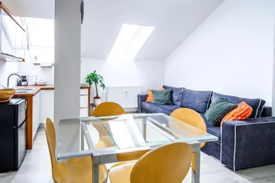 a living room with a glass table and a blue couch at The City Loft in Ljubljana