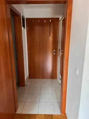 a hallway with a wooden door and a tile floor at Studio Mavrinc in Kranjska Gora
