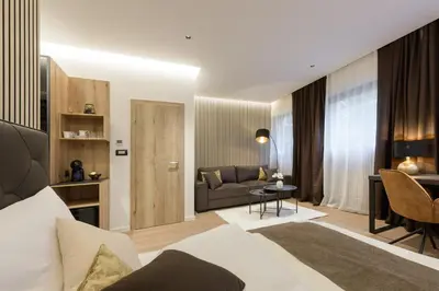 a bedroom with a bed and a couch and a table at ROYAL SUITE, Ljubljana in Ljubljana