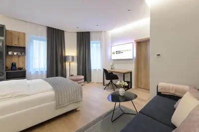 a bedroom with a bed and a living room at ROYAL SUITE, Ljubljana in Ljubljana