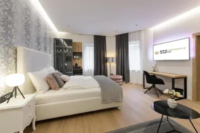 a bedroom with a large white bed and a desk at ROYAL SUITE, Ljubljana in Ljubljana