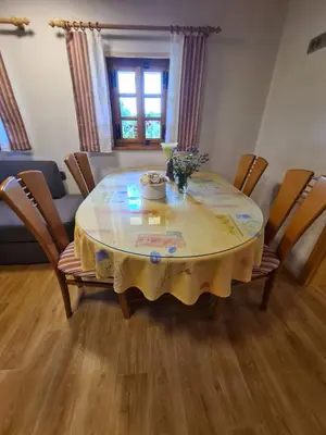 a dining room table with a yellow table cloth on it at Apartments Pajek & Pajčevina on the Hayrack in Dobje pri Lesičnem