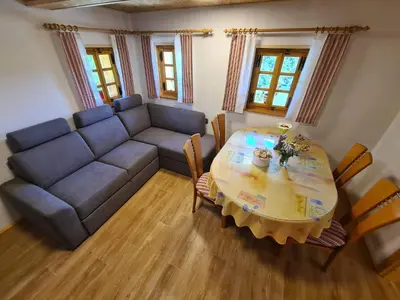 a living room with a couch and a table at Apartments Pajek & Pajčevina on the Hayrack in Dobje pri Lesičnem
