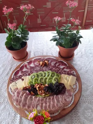 a plate of food on a table with plants at Apartments Pajek & Pajčevina on the Hayrack in Dobje pri Lesičnem