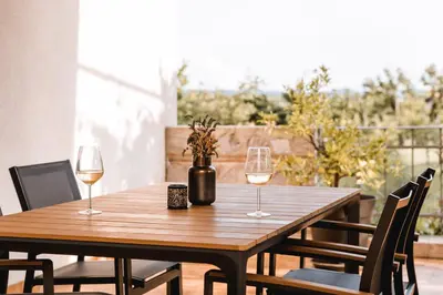 a wooden table with two glasses of wine at Vina Kobal, Kobal Family Estate in Štanjel