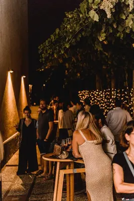 a group of people sitting at tables at a party at Vina Kobal, Kobal Family Estate in Štanjel