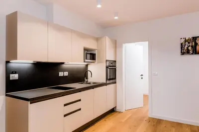 a kitchen with white cabinets and a black counter top at Vina Kobal, Kobal Family Estate in Štanjel