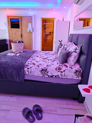 a bedroom with a large bed with purple sheets and pillows at Private wellness with panoramic view, sauna & jacuzzi in Maribor