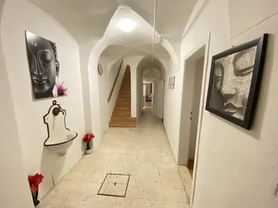 a hallway of a building with a staircase and art on the walls at Villa pod Gradom in Ljubljana