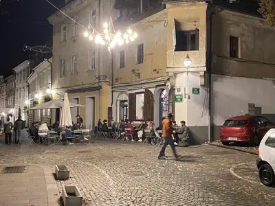 a man walking down a street at night at Villa pod Gradom in Ljubljana