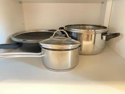 three pots and pans on a shelf in a kitchen at Villa pod Gradom in Ljubljana