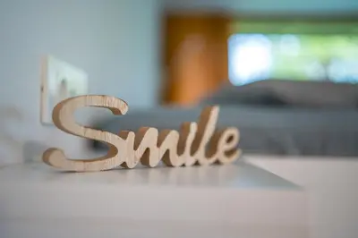 a wooden sign that says smile sitting on a table at Holiday house Hona Lux in Velike Lašče