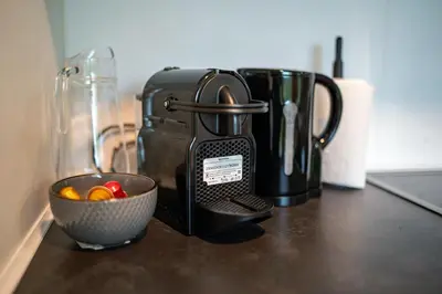 a coffee maker on a counter with a bowl of candy at Holiday house Hona Lux in Velike Lašče