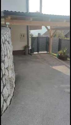 a patio with a stone wall next to a building at Veronika's House je prijeten, miren apartma v naravi, blizu mesta in Celje