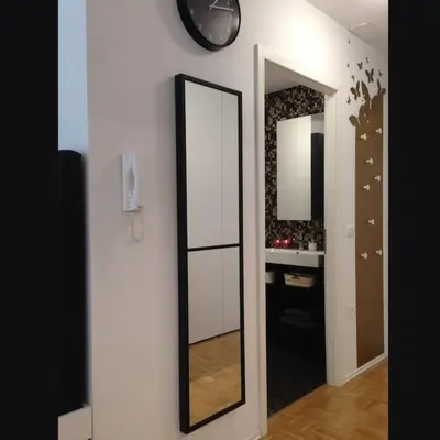 a mirror on a wall next to a bathroom at Gorgeous central flat with garage in Ljubljana