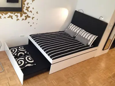 a bed with black and white sheets and stars on the wall at Gorgeous central flat with garage in Ljubljana