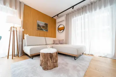 a living room with a couch and a tree stump table at Bor in Bor Luxury Apartment with sauna & garden - Kranjska Gora in Kranjska Gora