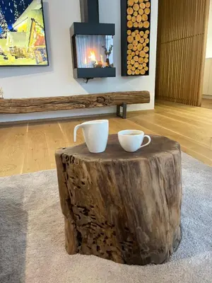 a tree stump coffee table with two cups on it at Bor in Bor Luxury Apartment with sauna & garden - Kranjska Gora in Kranjska Gora
