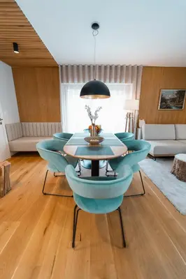 a dining room with blue chairs and a table at Bor in Bor Luxury Apartment with sauna & garden - Kranjska Gora in Kranjska Gora