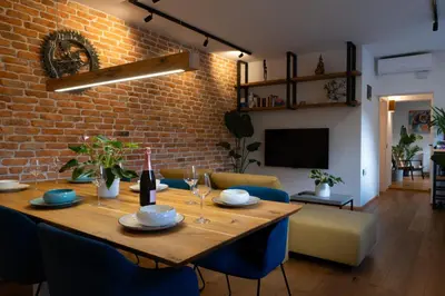 a dining room with a table and a brick wall at Vacation Station Kamnik in Kamnik